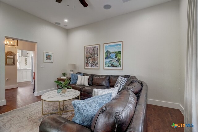 living room featuring ceiling fan and dark hardwood / wood-style floors