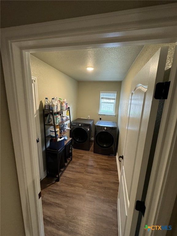 washroom featuring washing machine and dryer, a textured ceiling, and dark hardwood / wood-style flooring