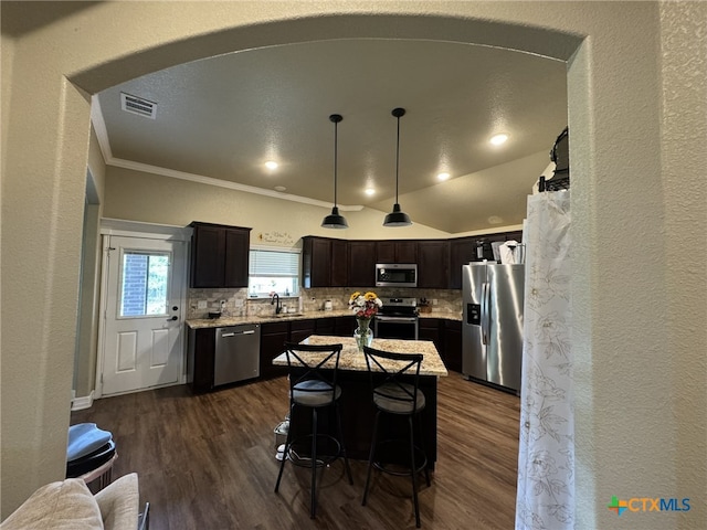 kitchen featuring a kitchen island, appliances with stainless steel finishes, dark hardwood / wood-style floors, decorative backsplash, and sink