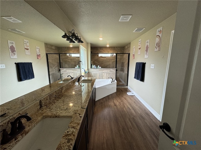 bathroom featuring vanity, hardwood / wood-style flooring, a textured ceiling, and shower with separate bathtub