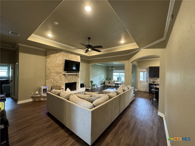 living room featuring ornamental molding, dark hardwood / wood-style floors, ceiling fan, and a tray ceiling