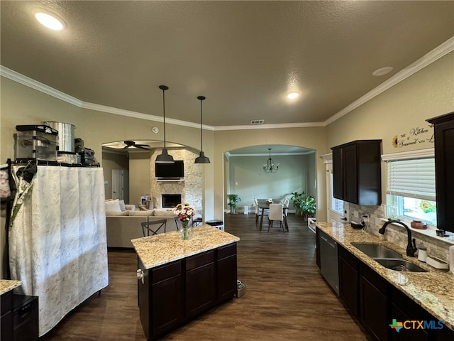 kitchen with sink, light stone counters, hanging light fixtures, dishwasher, and dark hardwood / wood-style flooring