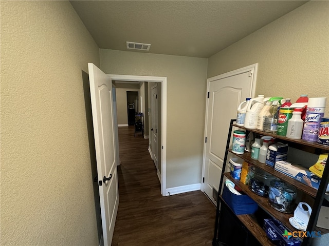 hallway with dark hardwood / wood-style flooring and a textured ceiling