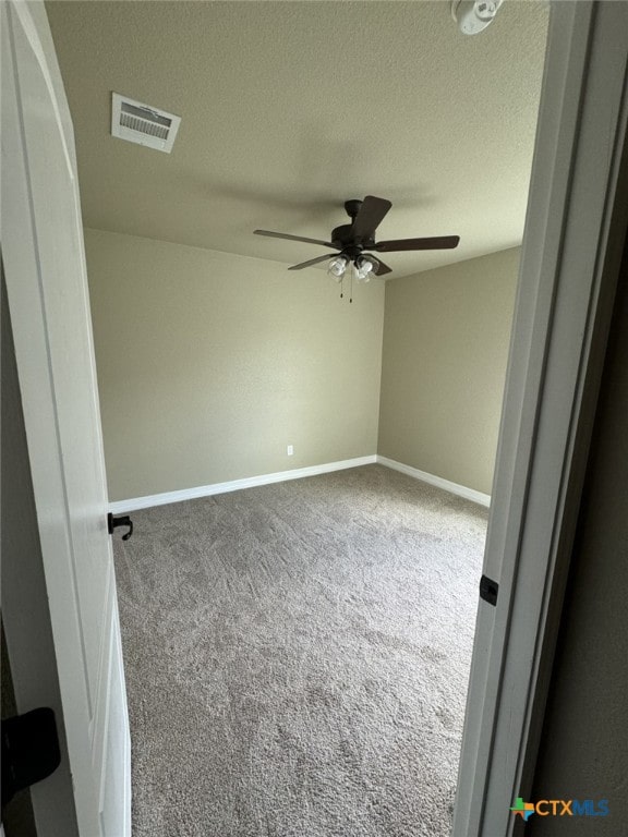 carpeted empty room with a textured ceiling and ceiling fan