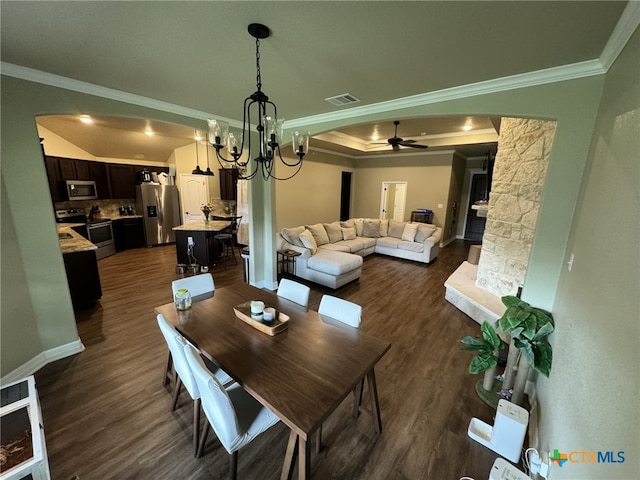 dining area with dark wood-type flooring, ceiling fan with notable chandelier, and crown molding