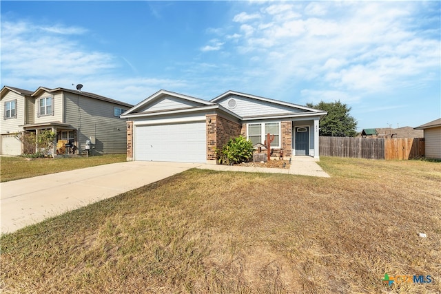 view of front of home with brick siding, concrete driveway, an attached garage, fence, and a front lawn