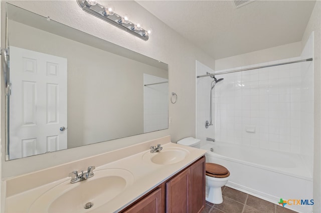 full bathroom with toilet, tile patterned flooring, a textured ceiling, tiled shower / bath combo, and vanity