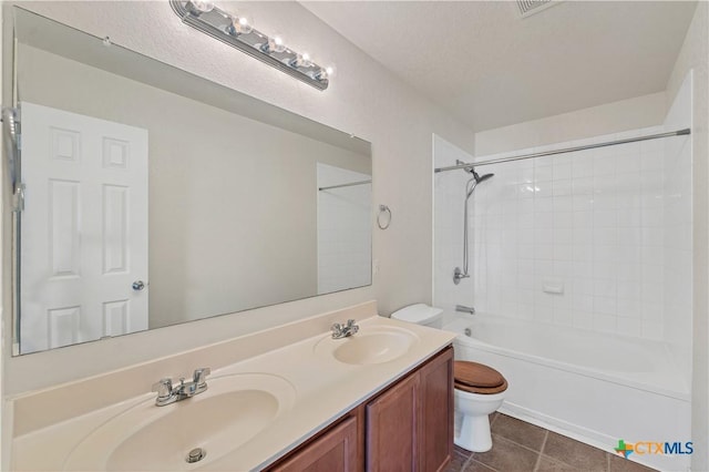 full bathroom with tile patterned flooring, a sink, toilet, and double vanity