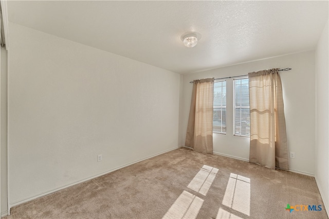 carpeted empty room with a textured ceiling