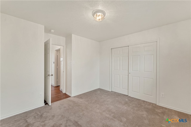 unfurnished bedroom with a closet and light carpet