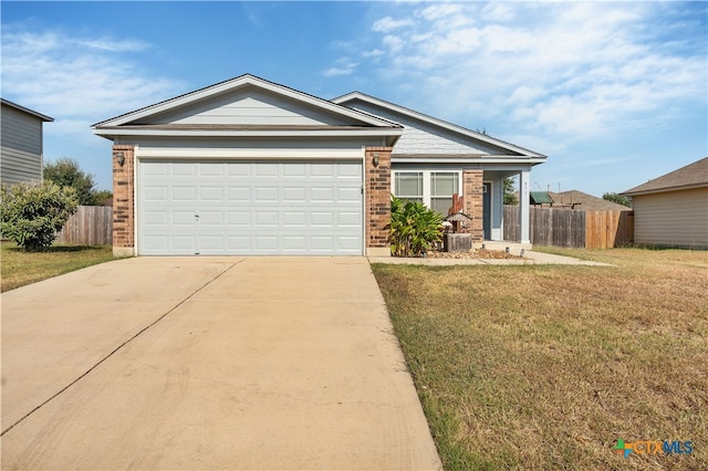 view of front facade featuring driveway, a garage, brick siding, fence, and a front yard