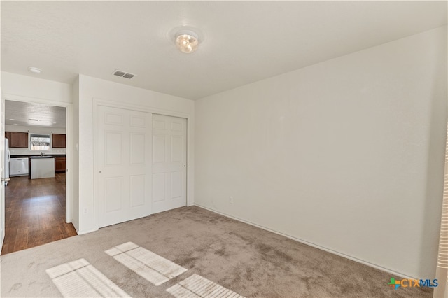 unfurnished bedroom featuring wood-type flooring and a closet