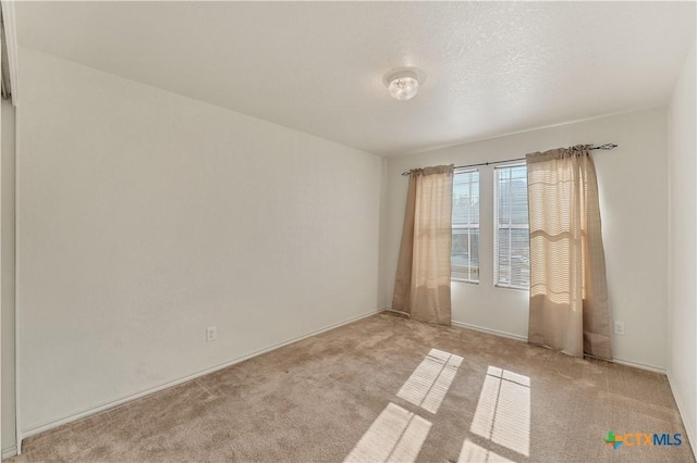 unfurnished room featuring light carpet