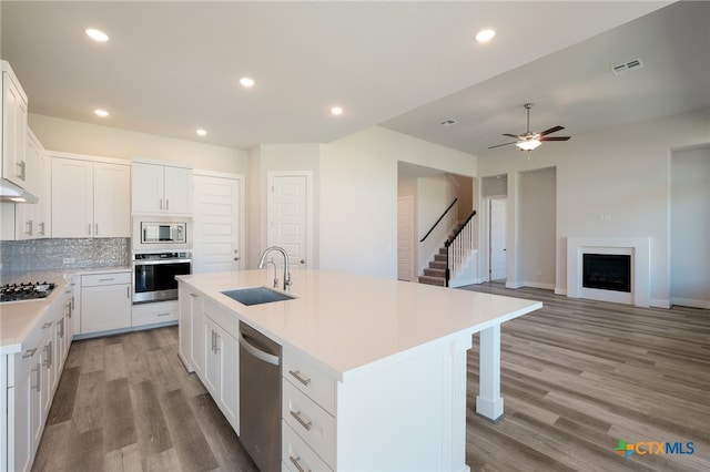 kitchen featuring appliances with stainless steel finishes, sink, an island with sink, and white cabinets