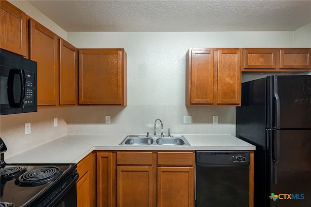 kitchen featuring sink, black appliances, and a textured ceiling