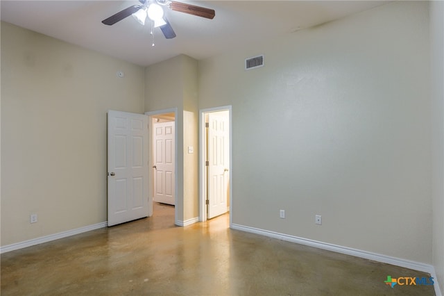 unfurnished room featuring ceiling fan and a high ceiling