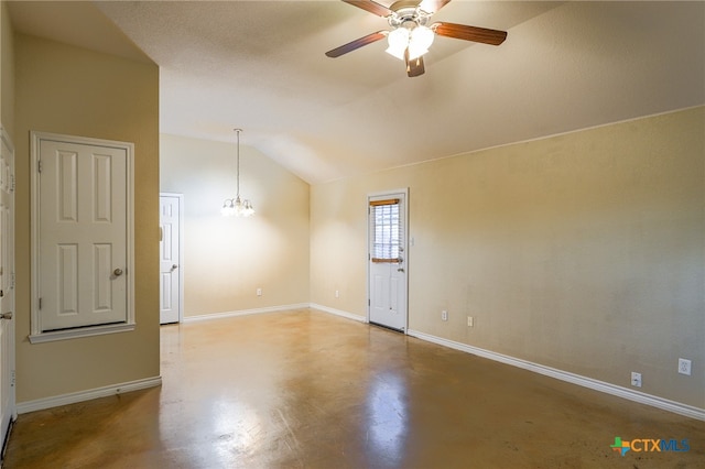 empty room with ceiling fan with notable chandelier, concrete floors, and vaulted ceiling