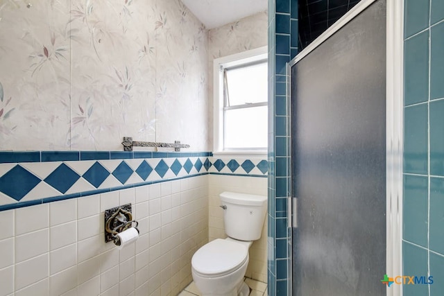 bathroom featuring toilet and tile walls