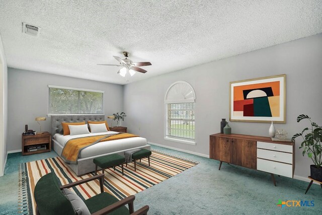 carpeted bedroom featuring ceiling fan, multiple windows, and a textured ceiling