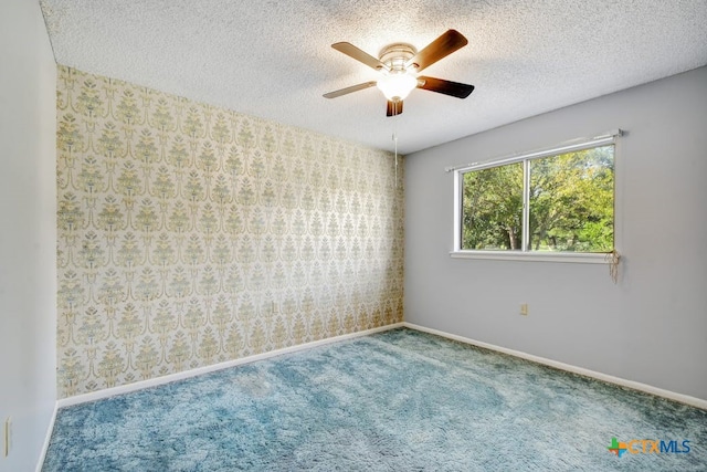 empty room featuring ceiling fan, a textured ceiling, and carpet floors