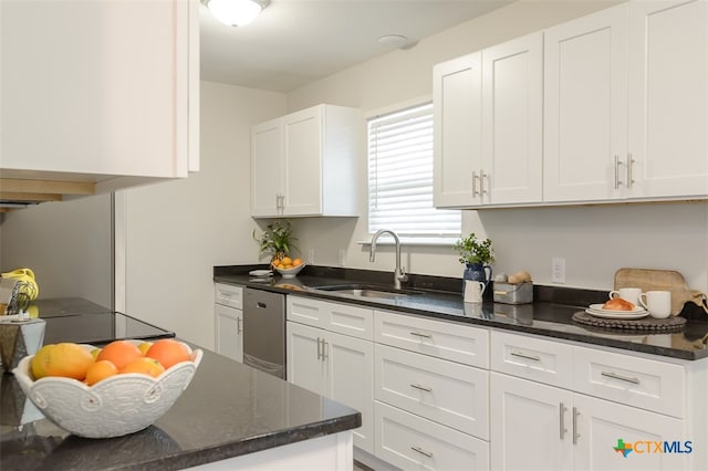 kitchen featuring white cabinets, dark stone countertops, dishwasher, and sink