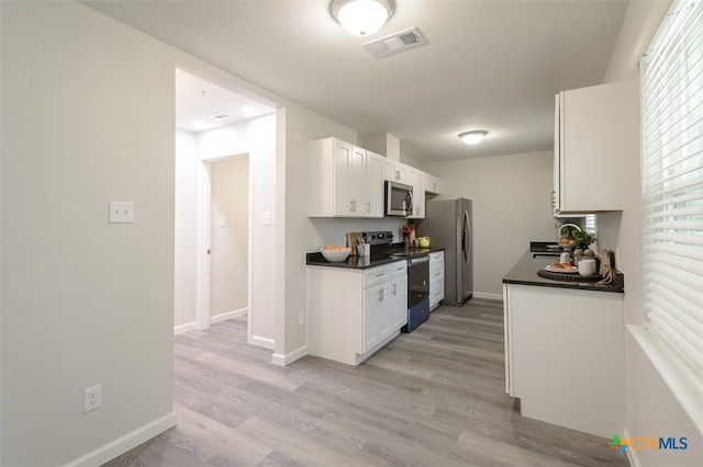 kitchen with white cabinets, stainless steel appliances, light hardwood / wood-style floors, and sink