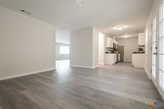 unfurnished living room featuring ceiling fan and light hardwood / wood-style flooring