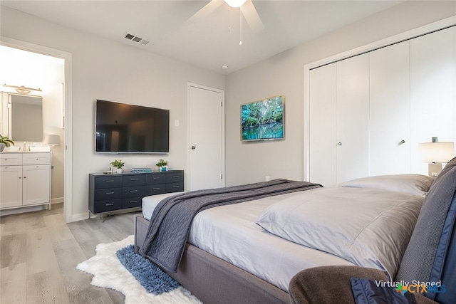 bedroom featuring light wood-type flooring, ensuite bath, and ceiling fan