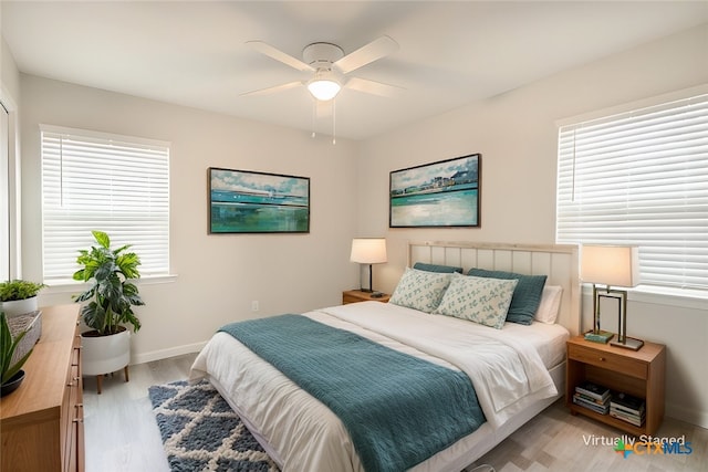 bedroom featuring hardwood / wood-style flooring, multiple windows, and ceiling fan