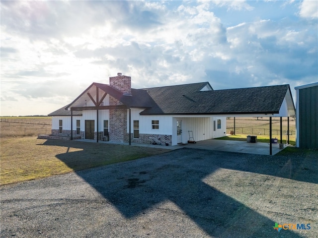 back of property with a yard and a carport