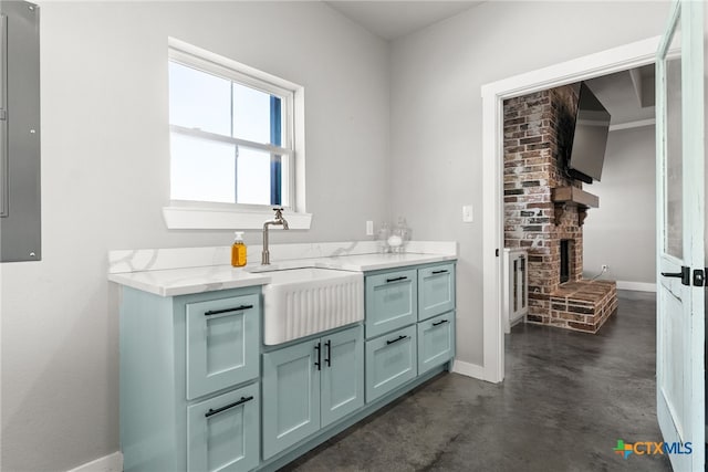 bar featuring sink, light stone counters, and a fireplace