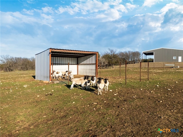 view of yard featuring an outdoor structure and a rural view