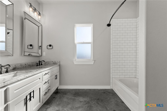 bathroom with vanity, concrete floors, and tiled shower / bath