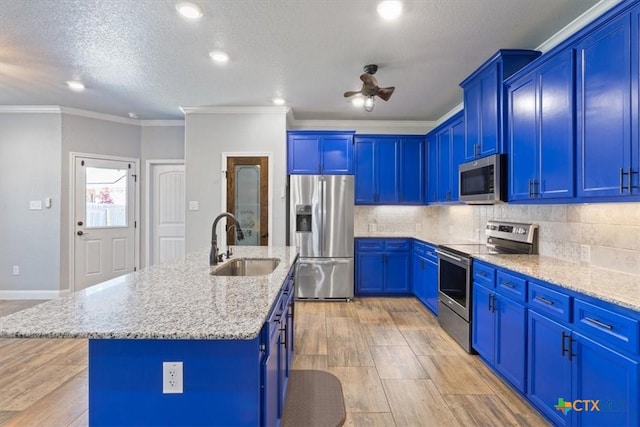 7516 Hardin Dr, Temple, TX 76502 - kitchen featuring stainless steel appliances, a sink, blue cabinets, light stone countertops, and ornamental molding