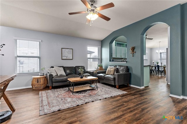 living room featuring dark hardwood / wood-style flooring, ceiling fan with notable chandelier, and lofted ceiling