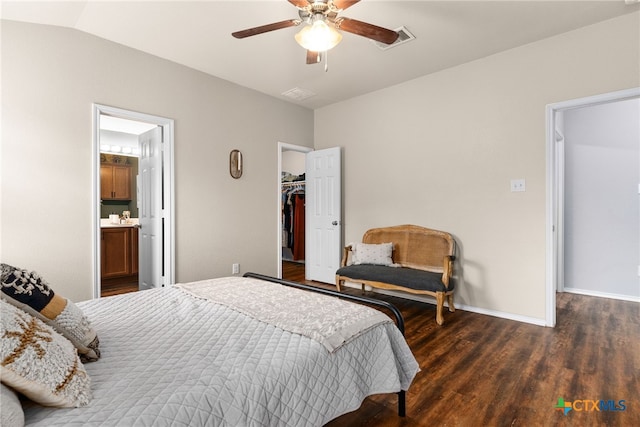 bedroom with dark hardwood / wood-style flooring, ensuite bathroom, ceiling fan, a spacious closet, and a closet