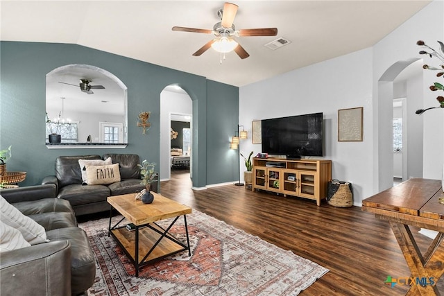 living room with dark hardwood / wood-style flooring, ceiling fan with notable chandelier, and vaulted ceiling