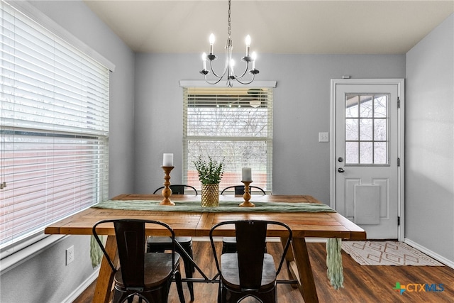 dining space with wood-type flooring and a chandelier