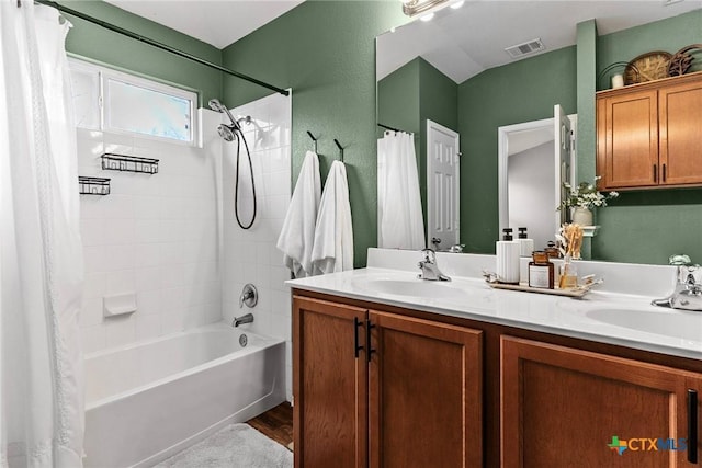 bathroom with hardwood / wood-style floors, vanity, and shower / tub combo