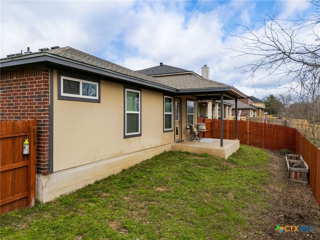 back of property with a lawn and a patio