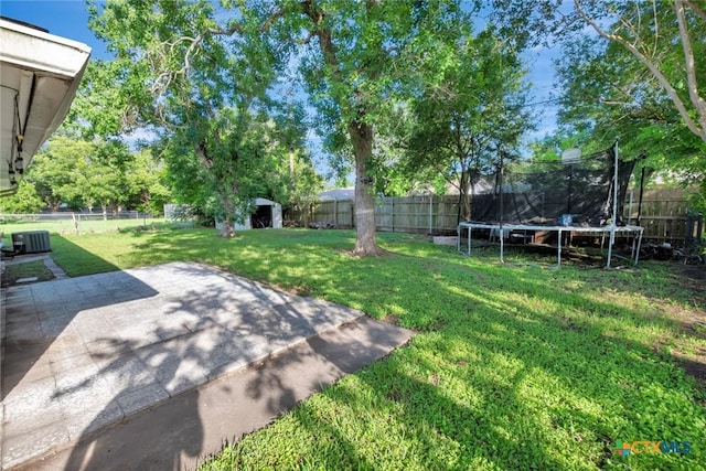 2307 E Airline Rd, Victoria, TX 77901 - fenced backyard featuring a trampoline, a patio area, and an outdoor structure