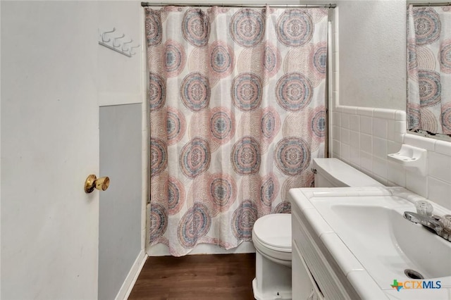 2307 E Airline Rd, Victoria, TX 77901 - full bathroom featuring wood finished floors, vanity, tile walls, and wainscoting