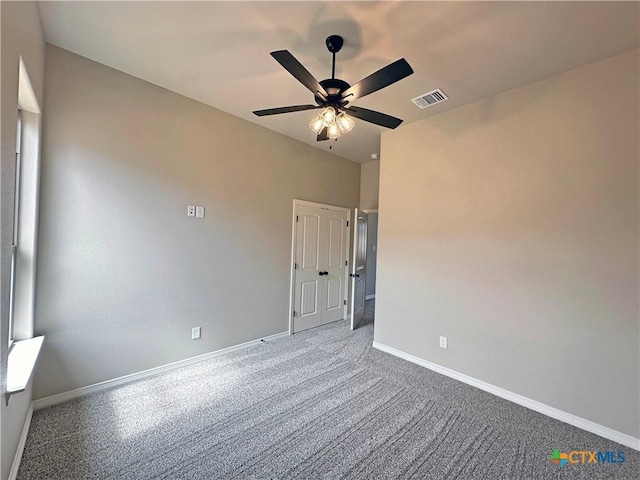 unfurnished room with carpet, visible vents, ceiling fan, and baseboards