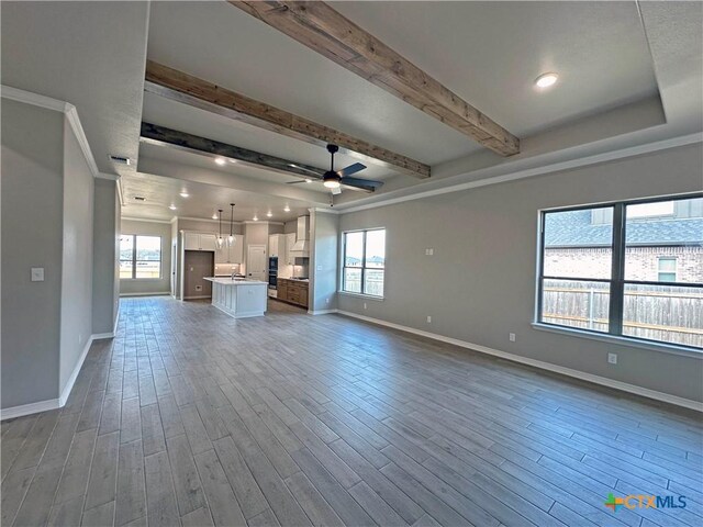 kitchen featuring white cabinetry, wall chimney range hood, crown molding, and a kitchen island