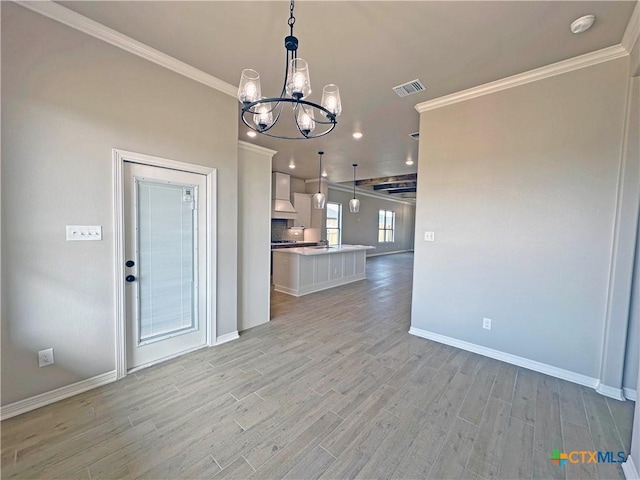 interior space featuring light wood finished floors, ornamental molding, open floor plan, premium range hood, and white cabinetry