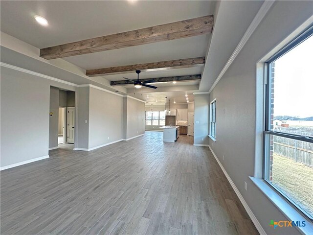 kitchen with a healthy amount of sunlight, white cabinetry, wall chimney range hood, and a kitchen island