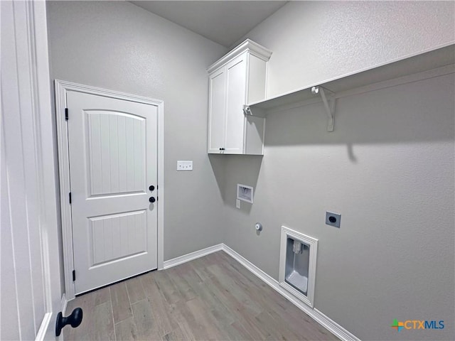 laundry room with gas dryer hookup, hookup for an electric dryer, baseboards, light wood-style floors, and cabinet space