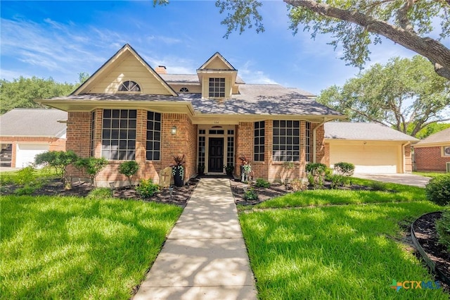 504 Masters Dr, Victoria, TX 77904 - view of front of house with brick siding, an attached garage, and a front lawn