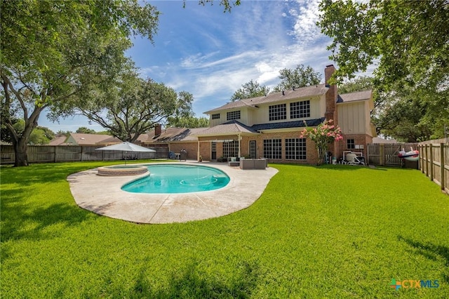 504 Masters Dr, Victoria, TX 77904 - rear view of house featuring a fenced backyard, a patio, brick siding, and a pool with connected hot tub