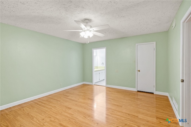 unfurnished bedroom featuring ensuite bathroom, ceiling fan, light wood-type flooring, a textured ceiling, and a closet